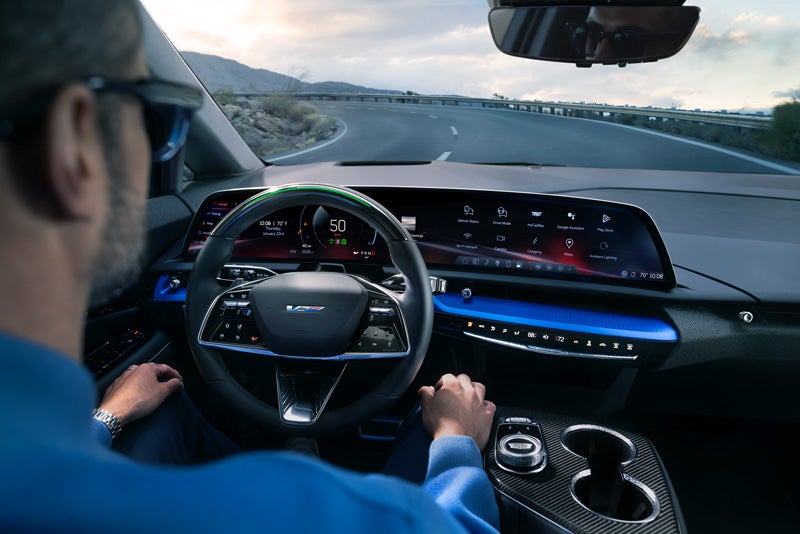 Front View of the 2026 OPTIQ-V Driving Through the Dusk Utilizing its Headlights | Medina Cadillac in MEDINA OH